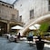 Guests dining at an outdoor café situated in a centuries old courtyard
